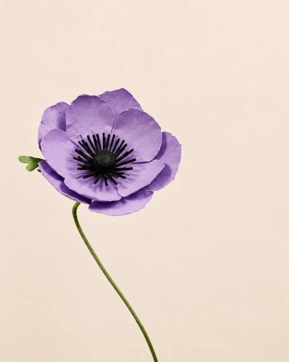 Anémone en papier violet, tige unique sur fond crème